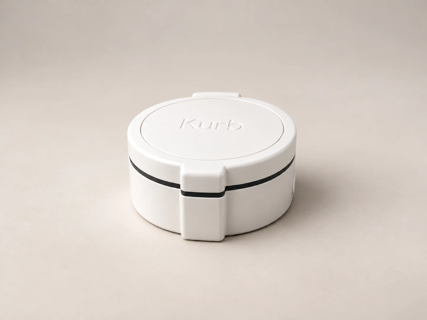 Closed white Kurb Zyn pilot case showing the circular lid, embossed Kurb logo, black seam, and front latch